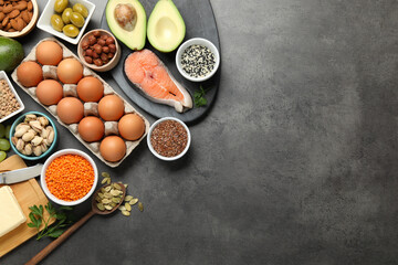 Different products high in natural fats on grey table, flat lay. Space for text