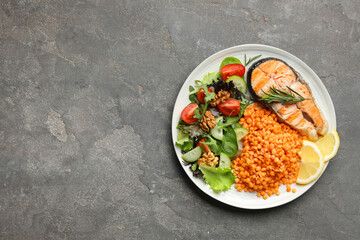 Plate with healthy food high in vegetable fats on grey textured table, top view. Space for text