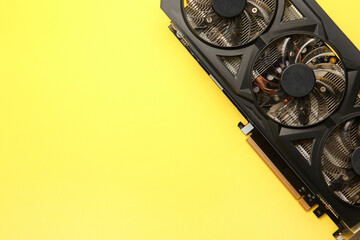 One graphics card on yellow background, top view. Space for text