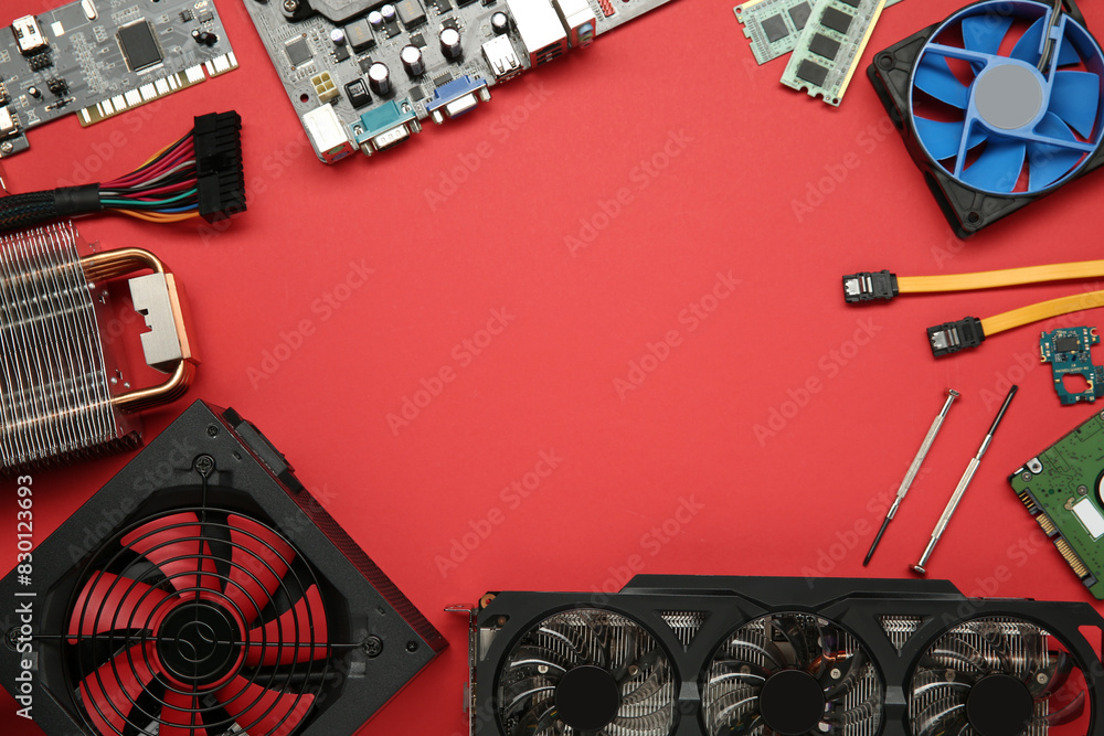 Fototapete frame of graphics card and other computer hardware on red background, flat lay. space for text