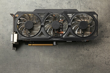One computer graphics card on grey textured table, top view. Space for text