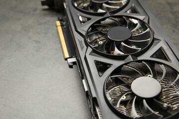 One computer graphics card on grey textured table, closeup. Space for text