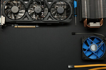 Graphics card and other computer hardware on black background, flat lay. Space for text