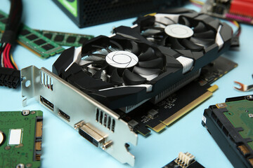 Graphics card and other computer hardware on light blue background, closeup