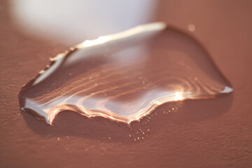 Beautiful volumetric drop of cosmetic product on a pink background.