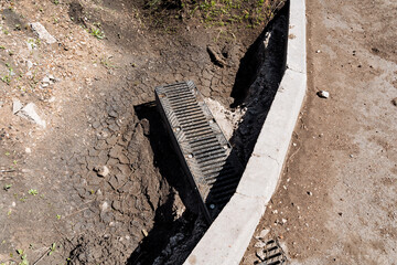 Drain being installed on road side to manage water runoff, improve landscape