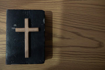 cross is placed on the Bible after prayer to God, which is religious ritual of Christianity and...