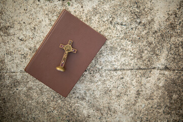 cross is placed on the Bible after prayer to God, which is religious ritual of Christianity and...