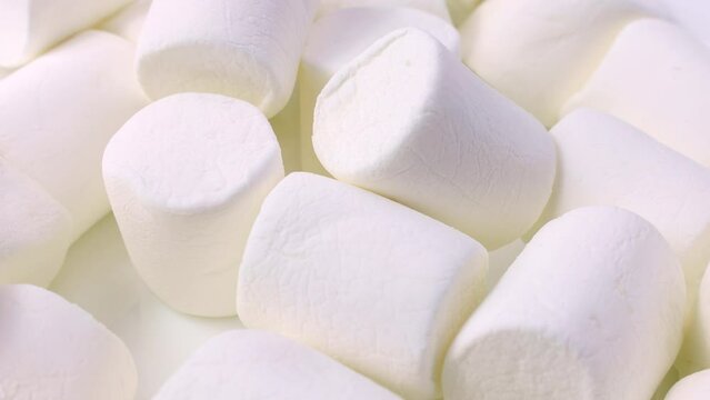 White tasty sugar marshmallow candy pieces falling down close up