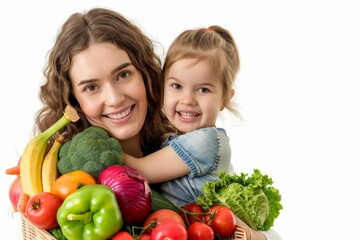 Fototapeta premium Happy mother and daughter holding a basket full of fresh vegetables, smiling at the camera on a white background.