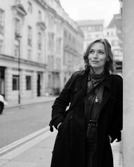 Analogue B&W portrait of female leaning on building in London.