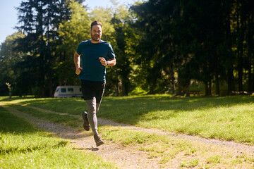 Full length of athlete running in nature.