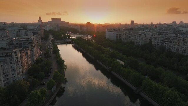 Sunset over Bucharest. Aerial drone 4k video view over Unirii Square, Boulevard and Palace of the Parliament from Bucharest, summer sunset sky landscape photo. Travel to Romania.