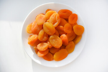 Dried fruits. Dried apricots. Dried apricots in close-up on a white plate.
