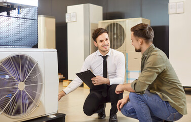 In a shop, store, an air conditioner salesman assists a consumer before buying an appliance....