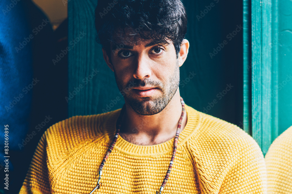 Poster portrait of bearded young man with eyeglasses on neck looking at camera while checking email on smar