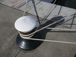 Mooring bollard with mooring lines on concrete ship dock