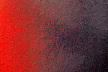 Macro close-up of a wall spray painted with bright red, purple and black. Abstract full frame...