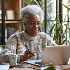 Senior Woman Working on Laptop. Modern Elderly Professional in Home Office. Concept of mature female remote freelance work. Active life of retired, pensioner using technology