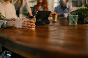 Close up of a businesswoman holding coffee to go in boardroom on meeting