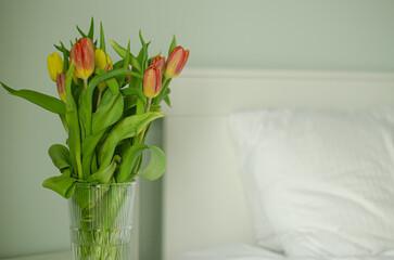 Bouquet of tulips near the bed, peony tulips in the bedroom. High quality photo