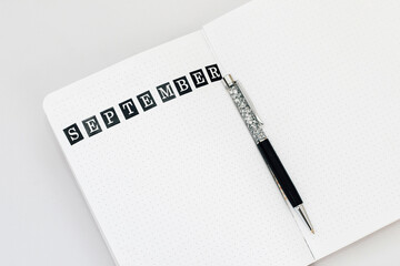 Filling in the diary, writing September in the notebook in a dot