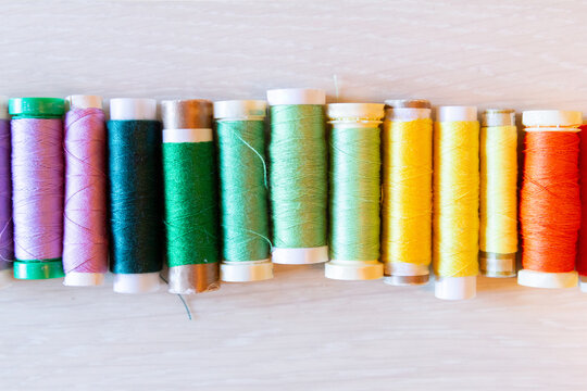Colorful sewing threads lined up on a light background