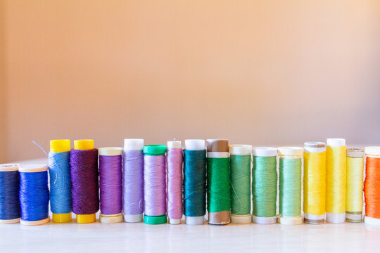 Vibrant Thread Spools Lined Up on Neutral Background