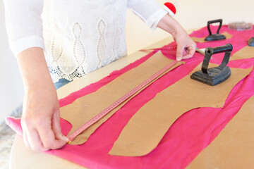 Tailor Measuring Fabric with Tape on Crafting Table