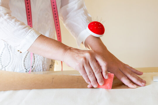 Tailor marking patterns on fabric in sewing workshop