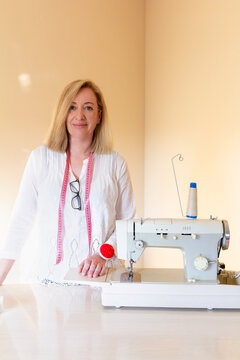 Tailor standing with equipment in sewing workshop
