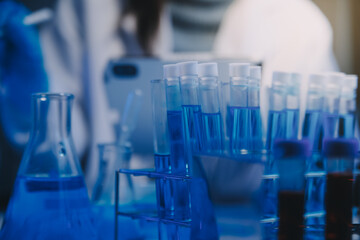 chemist,scientist hand dropping chemical liquid into test tube, science research and development concept