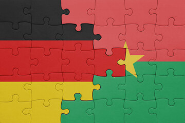 Fototapeta premium puzzle with the colourful national flag of burkina faso and flag of germany.