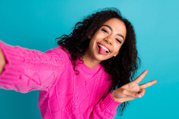 Portrait of nice young girl take selfie show tongue v-sign wear pink pullover isolated on turquoise...