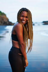 Portrait of cute afro american sportwoman with dreads smiling at camera.Cheerful young woman with...