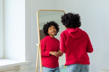 Love yourself. Beautiful young smiling african american woman dancing enjoying her mirror...