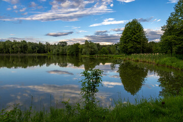 Clouds before sunset reflected in pond water