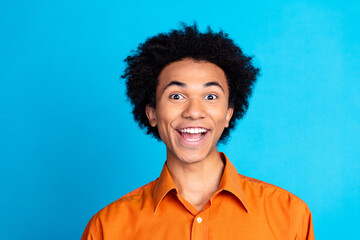 Photo of funky excited guy dressed orange shirt open mouth emtpy space isolated blue color...