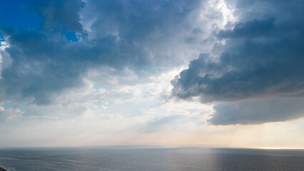 Beautiful sunset over the sea, ocean. Top view from a quadcopter. Beautiful flight. Ships and windmills on the horizon. The rays of the sun break through the clouds.