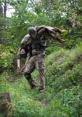 The commander carries a wounded soldier