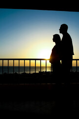 Beautiful couple silhouette on nature near the sea on a rift background
