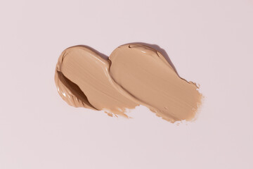 Makeup foundation, beige concealer swatch smudge smear on pink background. BB CC cream texture