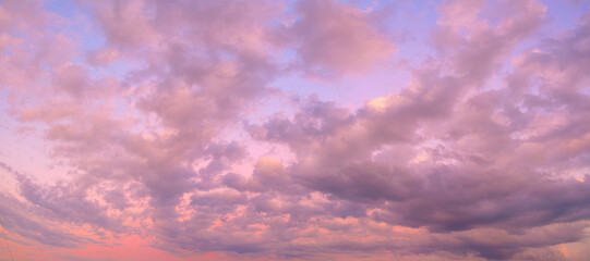 A beautiful pink and orange sky with clouds. The sky is filled with clouds and the sun is setting