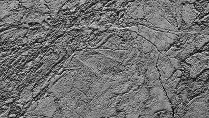 Fototapeta premium A grey stone wall with a rough texture. The wall is covered in small, jagged rocks