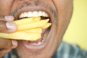 hungry man eating fries closeup