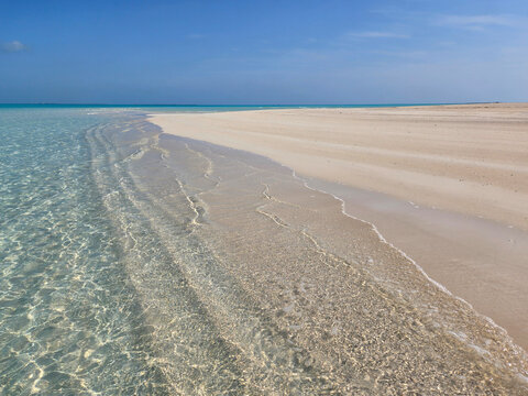Sandbar and clear shallow water of Treasure Cay, Abaco, Bahamas on sunny summer day.