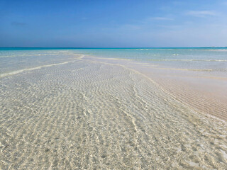 Sandbar and clear shallow water of Treasure Cay, Abaco, Bahamas on sunny summer day.