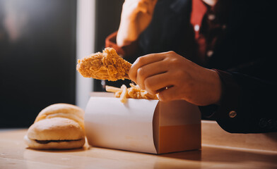 close up focus woman hand hold fried chicken for eat,girl with fast food concept