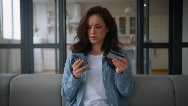Caucasian confused girl female buyer client customer woman on sofa home couch buy credit card mobile phone try pay bank app problem no money insecure online payment scam fraud unsuccessful transaction