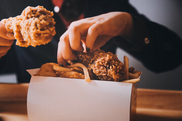 close up focus woman hand hold fried chicken for eat,girl with fast food concept